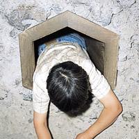 六角形の木枠から上半身が出ている男性の写真